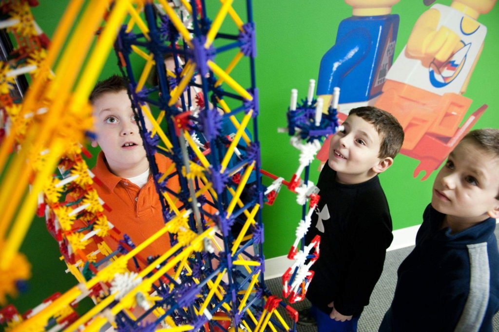 Boys look up at Lego structure.